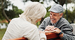 Mature couple, laughing and smile in park for bonding, conversation and commitment together outdoors. Retirement, marriage and elderly man and women in nature on bench for love, care and connection