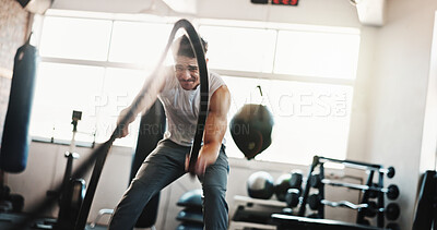 Buy stock photo Fitness, battle rope and man in gym for bodybuilding training, exercise and intense workout. Sports, serious and people with weightlifting equipment for muscle strength, performance and challenge