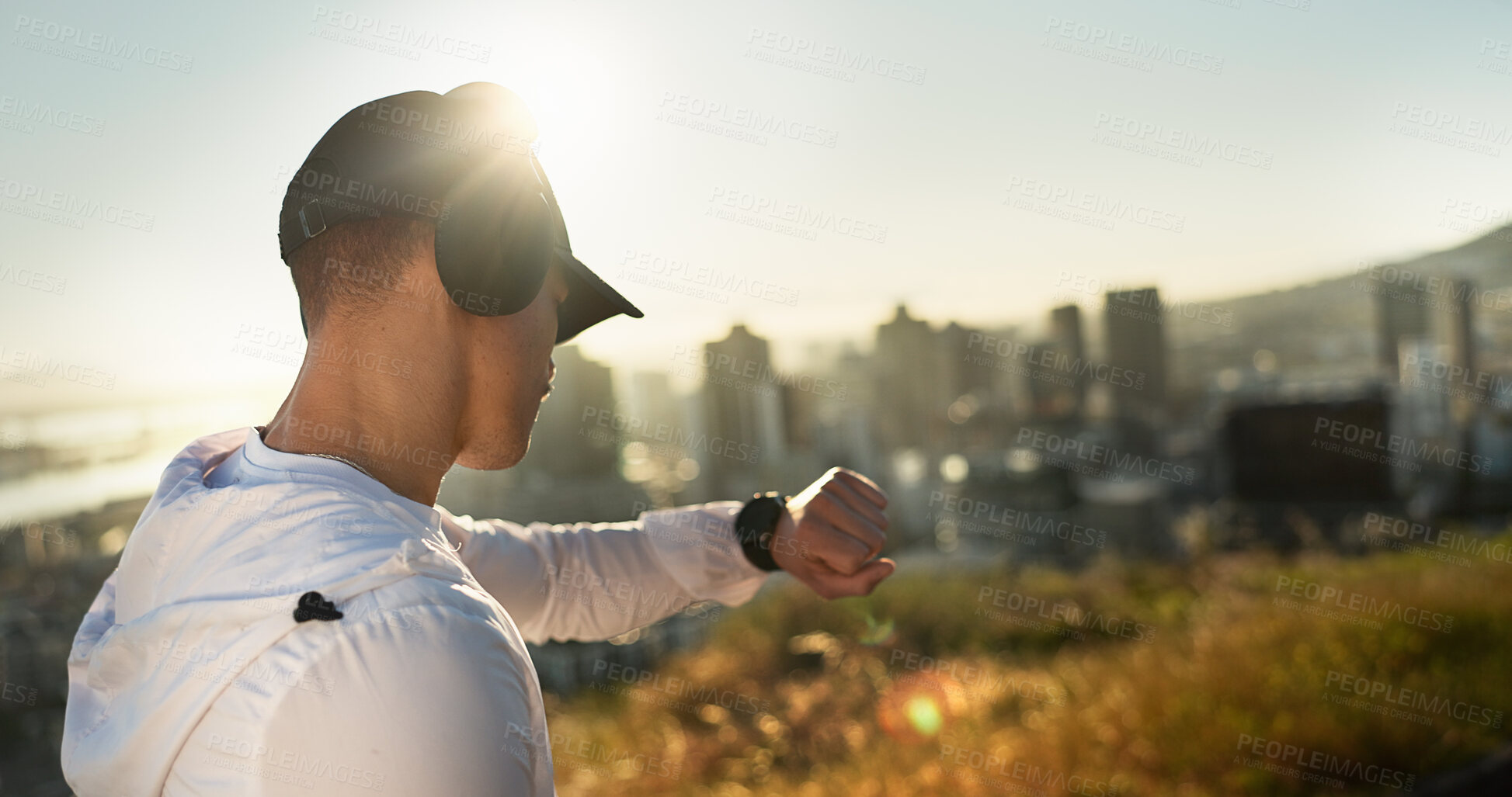 Buy stock photo Man, headphones and time outdoor for fitness, music and streaming radio with app, audio or workout. Male person, smart watch and training for challenge, biometric and morning run with health tracker