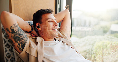 Buy stock photo Man, earphones and relax by window in home with smile, memory and reflection with music in morning. Person, ear pods and happy with audio streaming, subscription and thinking on couch at apartment