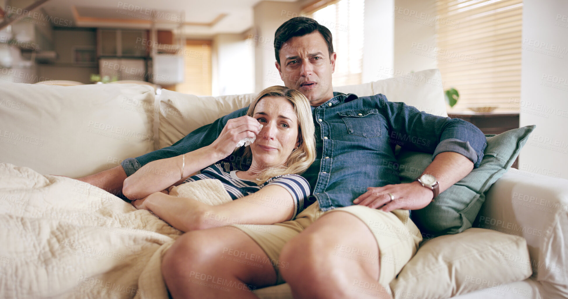 Buy stock photo Watching TV, sad and couple crying in home for bad news, movie and support on sofa. Man, woman and emotional in living room with empathy, heartbroken and streaming media with care in relationship