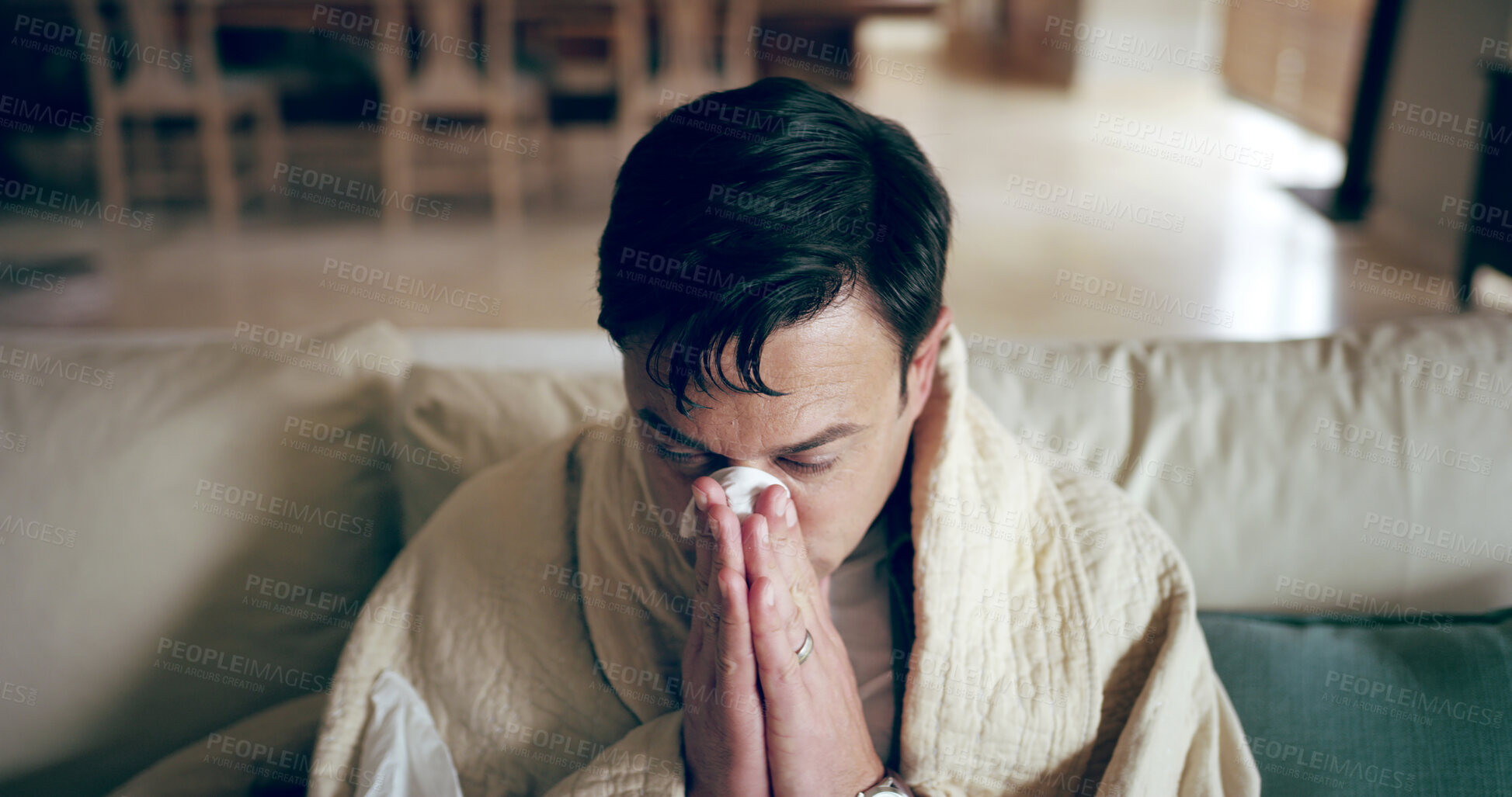 Buy stock photo Man, sick and blow nose on sofa with tissues, Covid 19 symptoms and flu season in home. Person, blanket and self care in living room with virus, spring allergies and sneezing with medical condition