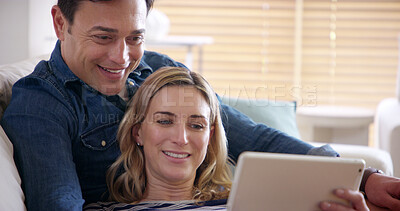 Buy stock photo Happy, couple and tablet on couch in home with streaming, series and technology with smile from meme. Internet, watching and love of people with app, online and fun together on weekend with care