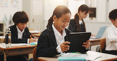 Buy stock photo Girl, tablet and learning in classroom with smile, education or reading on web with research for project. School kids, learner and digital touchscreen for assessment, test or info at academy in Japan