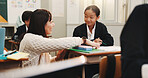 Conversation, woman and students in classroom, help and development with advice, education and learning. People, children and female teacher with knowledge, ideas and literature with smile and Japan