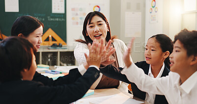 Buy stock photo Teacher, children and high five in classroom for teamwork development, group project and growth. Japanese students, hands together and unity with educator for support, knowledge and celebration