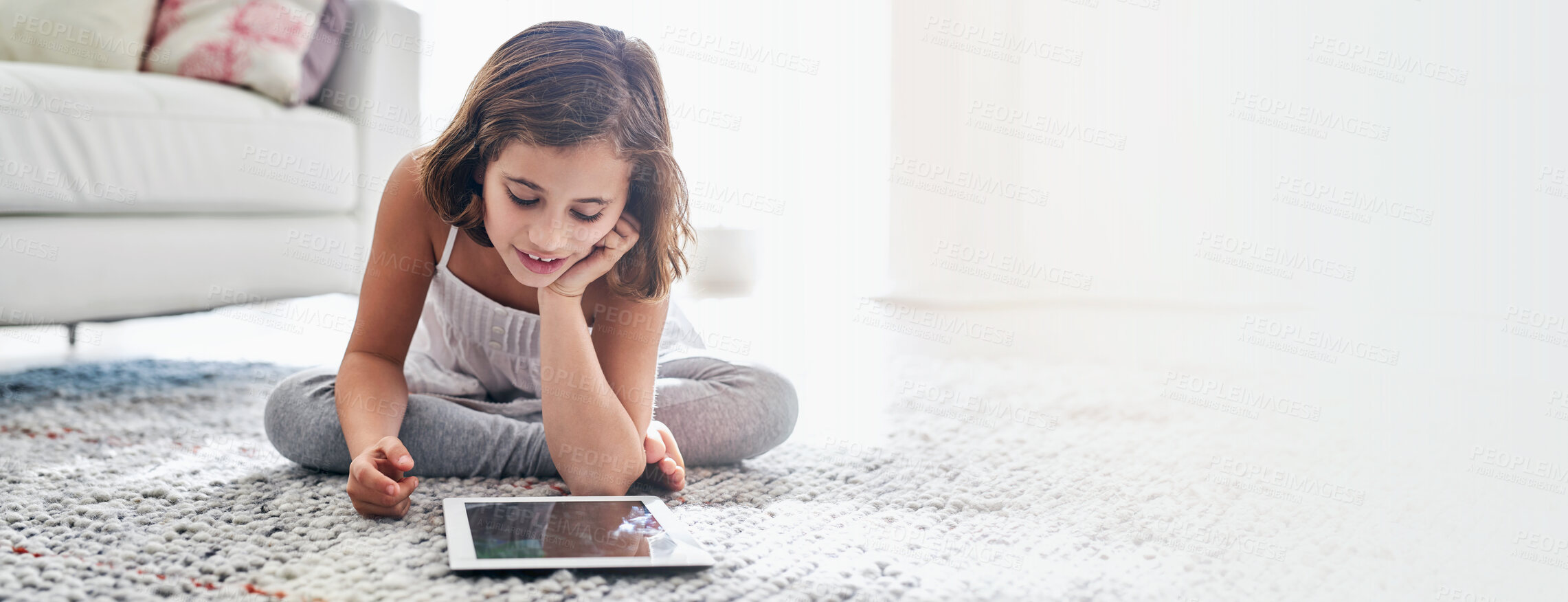 Buy stock photo Streaming, movies and child with tablet, home and watching of cartoons, relax and smile for video. Living room, banner and entertainment for kid, digital and subscription to app and mockup space