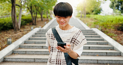 Buy stock photo Smile, phone and text of Japanese man by city steps with social media, happy and web scroll outdoor. University, campus and college student with morning commute, travel and mobile networking in park