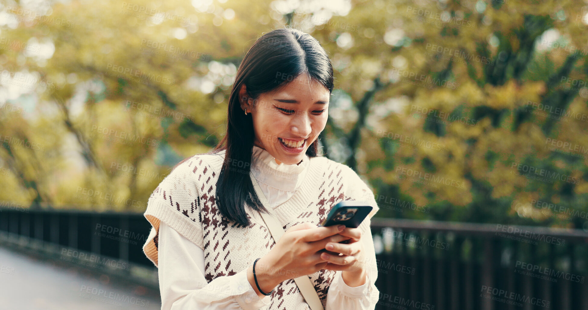 Buy stock photo Japanese woman, laughing and phone in street for online networking, dating app and funny text message. Person, smartphone and happy for social media meme, notification and browsing internet on bridge