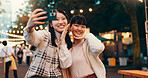 Happy, friends and Asian women with selfie in city at night market for fun, bonding and relax. Travel, weekend and people with photo for profile picture, social media post or memory at Japan festival