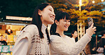 Japanese women, selfie and happy in town for friendship, memory and photography in city street. Female people, smile and night in bonding together as university student on holiday, travel or vacation