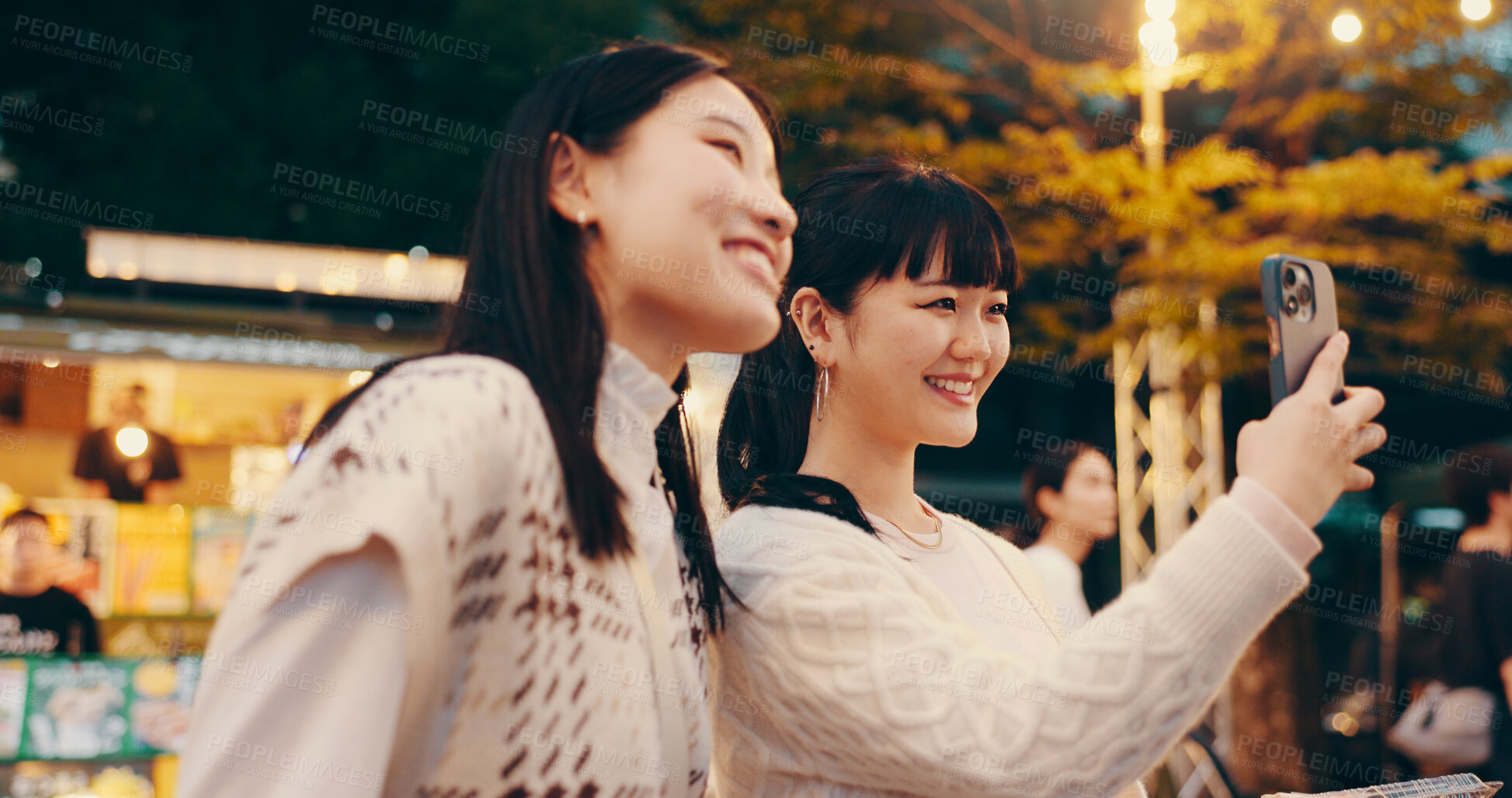 Buy stock photo Japanese women, selfie and happy in town for friendship, memory and photography in city street. Female people, smile and night in bonding together as university student on holiday, travel or vacation