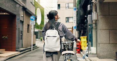 Buy stock photo City, walking and back of Asian woman with bicycle for commute to university, college and school. Student, cycling and person on bike for travel, sustainability and eco friendly transport in Japan