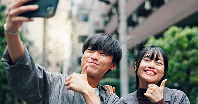 Buy stock photo Happy, asian couple and city with thumbs up for selfie, photography or memory together in street. Japanese, man and woman with yes sign or like emoji for moment or picture in an urban town in Tokyo
