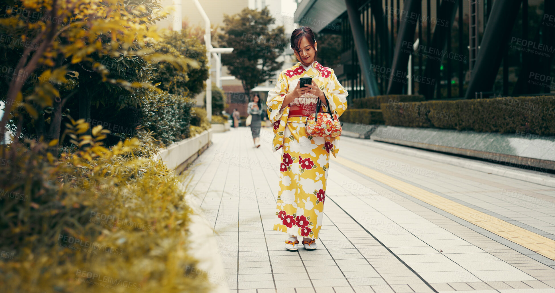 Buy stock photo Walking, phone and Japanese woman in city in kimono for travel on vacation, holiday or getaway. Cellphone, commuting and person in urban town for adventure on weekend trip with cultural fashion.