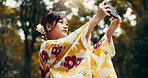 Photography, phone and kimono with Japanese woman in nature for picture, memory and traditional clothes. Travel, social media post and content creator with person for heritage, culture and update
