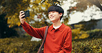 Selfie, influencer and man in park with smile, outdoor live streaming or online communication. Nature, photography and Japanese streamer with content creation, networking or social media connectivity