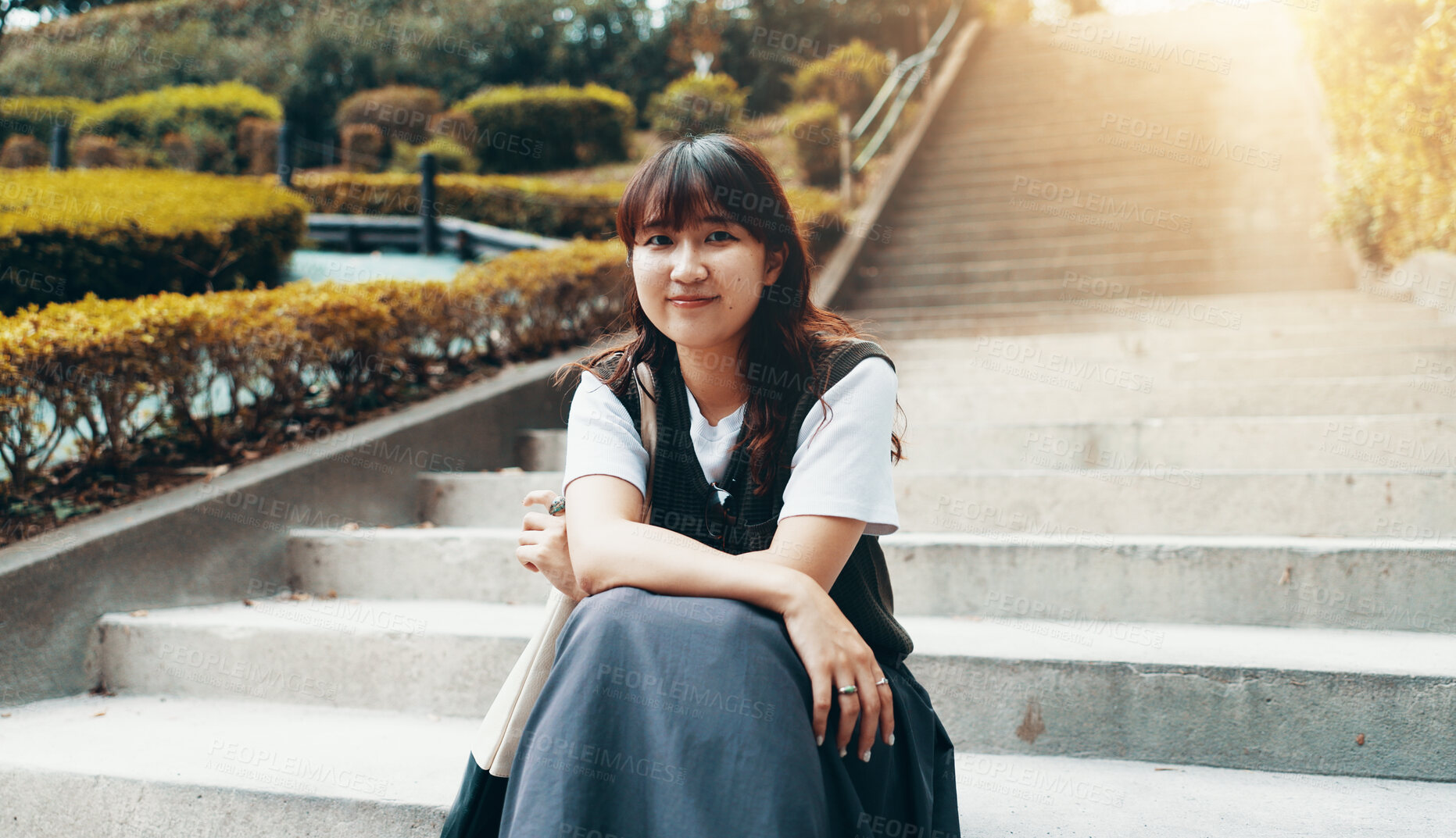 Buy stock photo Girl, college student and portrait on stairs, outdoor and happy on break at campus in sunshine. Woman, person and smile on steps in garden with pride, confidence and education at university in Japan