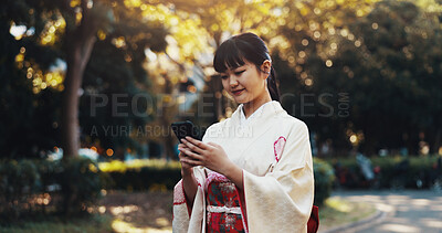 Buy stock photo Japanese woman, park and phone text with mobile notification, tech and social media outdoor. Fashion, student and campus with website, internet and contact with traditional kimono and message