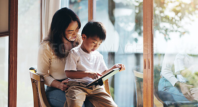 Buy stock photo Education, reading or tablet with mother and son on chair in home for child development or learning. Japanese family, study or technology with single parent woman and boy in apartment for search