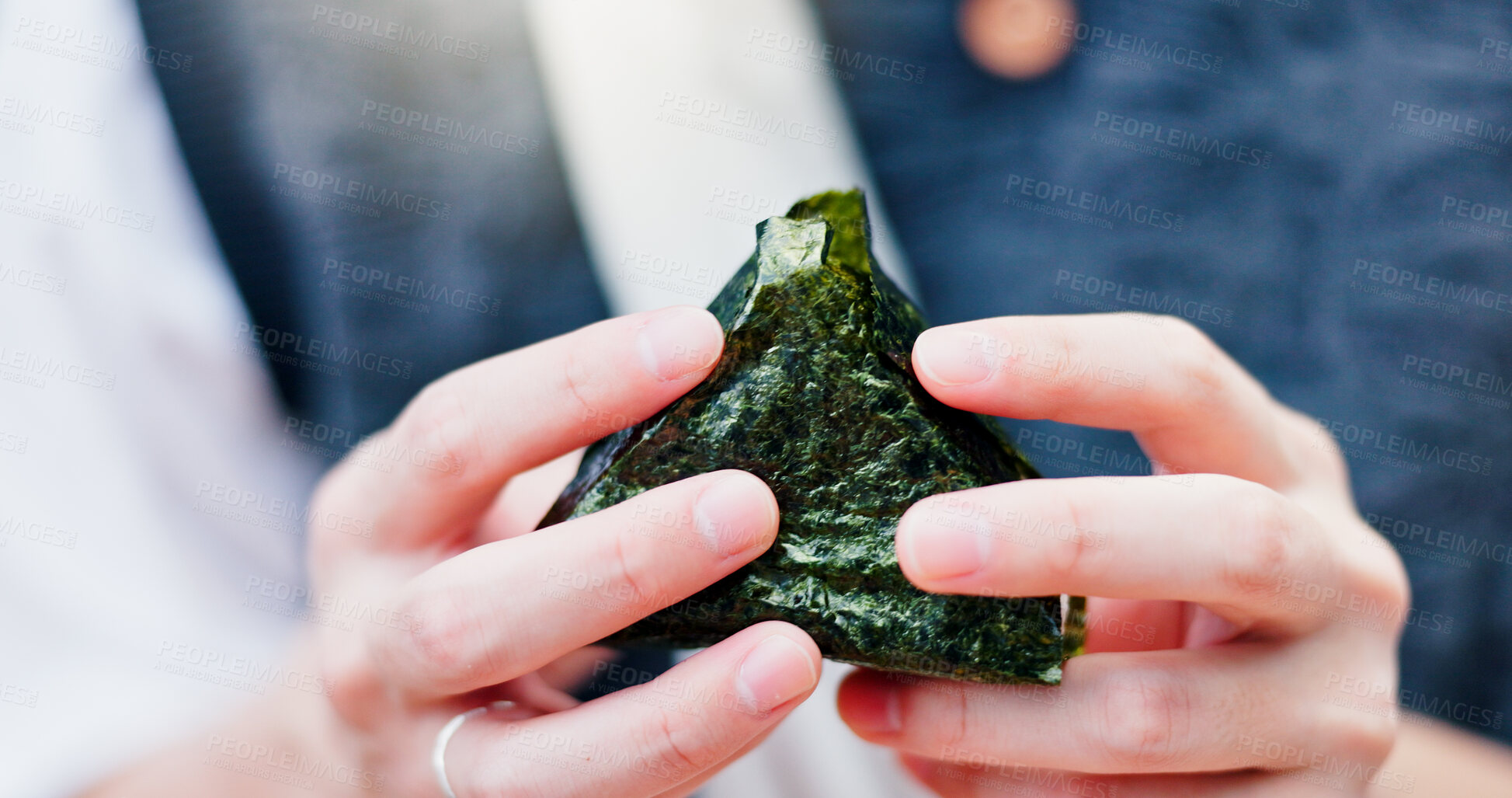 Buy stock photo Hands, person and rice ball in Japan for food, traditional snack or fresh natural seaweed triangle for culture. Onigiri, closeup or eating meal for organic lunch, hungry or healthy diet for nutrition