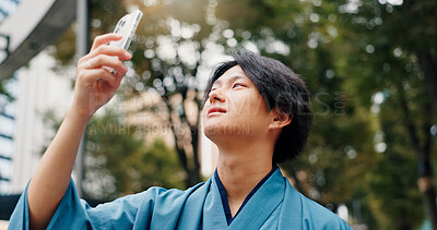 Buy stock photo Photography, cellphone and Japanese man in nature for travel, vacation or weekend trip location. Phone, destination and male person outdoor for pictures on tech for journey, adventure or holiday.