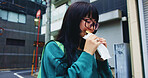 Travel, eating and woman with food in city on vacation, adventure or weekend trip for journey. Happy, pastry and hungry Japanese female person enjoying Taiyaki for lunch in urban town on holiday.