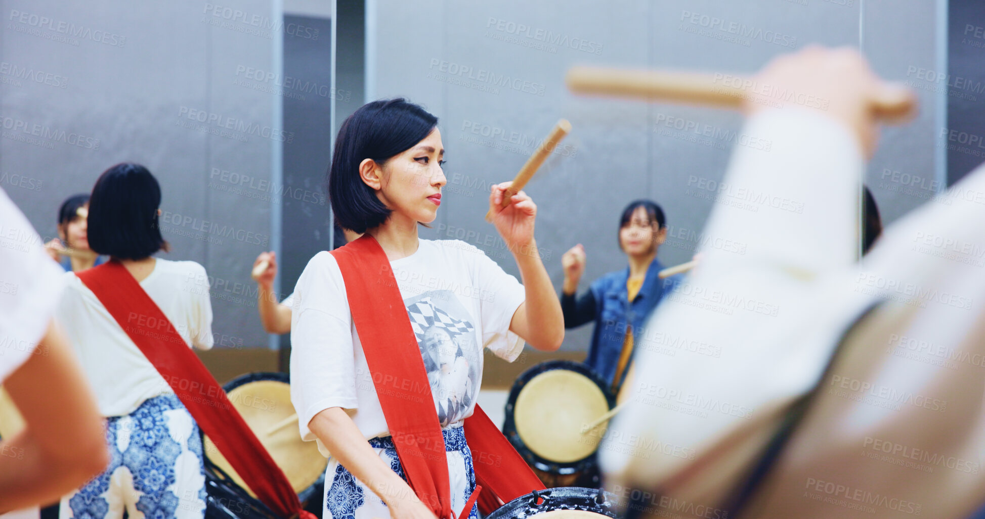 Buy stock photo Japanese, learning and woman with drums for music on instrument for performance, practice and class. Taiko, people or female drummers in band to play in group rehearsal for culture, rhythm or beat