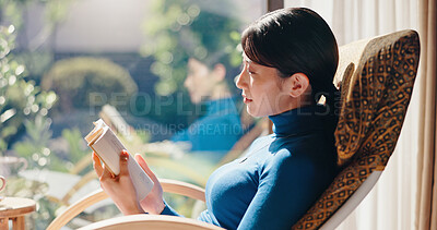 Buy stock photo Reading, rest and Asian woman with novel, morning and knowledge with literature, relax and weekend. Home, reader and person with book, break and comfortable with story, chair and cozy in Japan