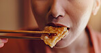 Person, mouth or bite with chopsticks for eating, hungry snack or taste for delicious meal or protein at home. Japan, closeup or food with wooden or bamboo utensils for tradition, culture or heritage