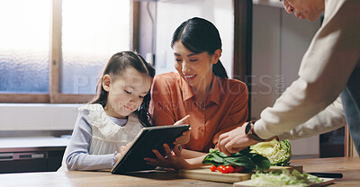 Buy stock photo Mom, girl and tablet in kitchen with father, cooking and happy with streaming, recipe or teaching in family home. People, mother and daughter with touchscreen, food and meal prep at house in Japan