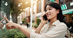 Phone call, communication and woman in city for vacation, travel or weekend trip with direction board. Happy, cellphone and Japanese female person on mobile conversation for networking o holiday.