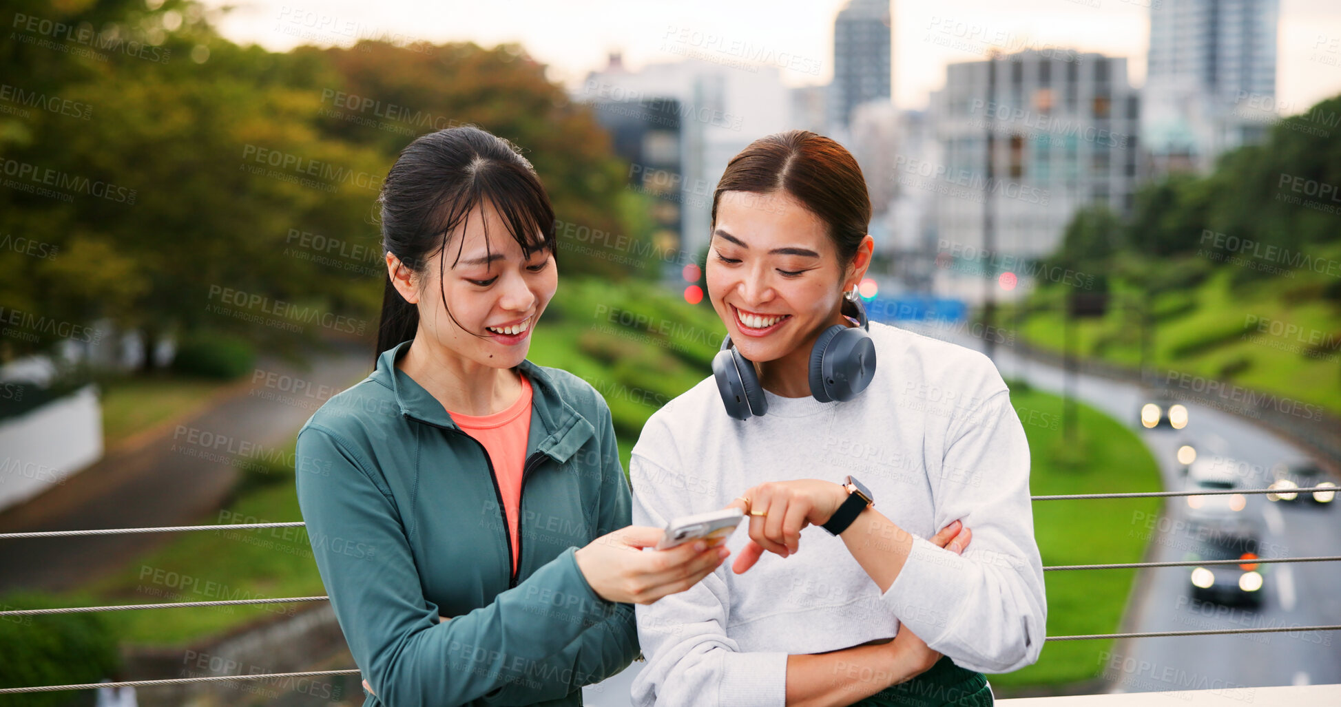 Buy stock photo Fitness, happy friends and women with phone in city for social media, training app or show text. Japanese girls, sports and outdoor with mobile for body health, exercise results or tracking wellness