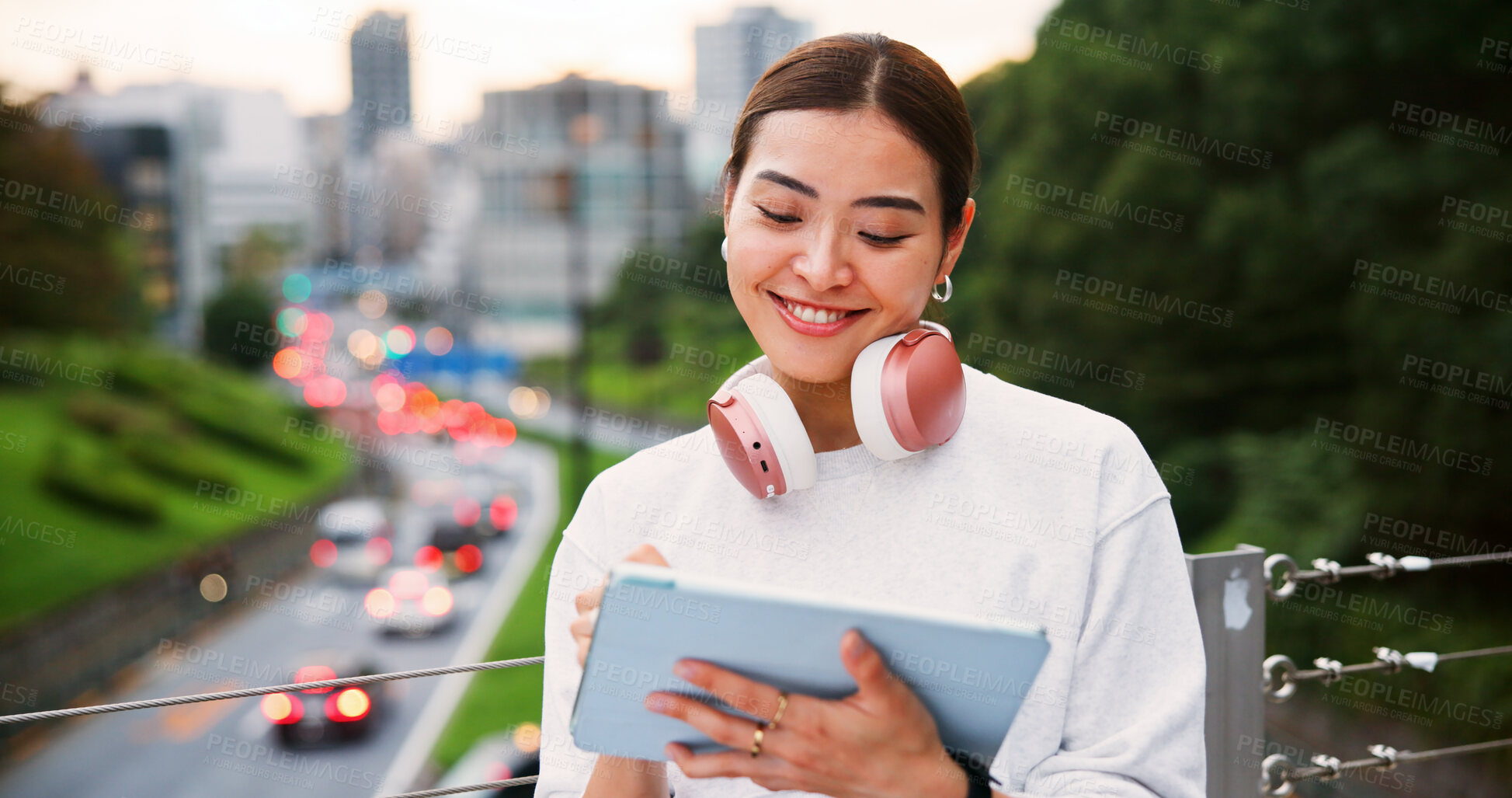 Buy stock photo Happy, woman and writing on tablet in city for graphic design, digital illustration and creative process. Female artist, headphones and drawing for website, editing update and project on Japan bridge