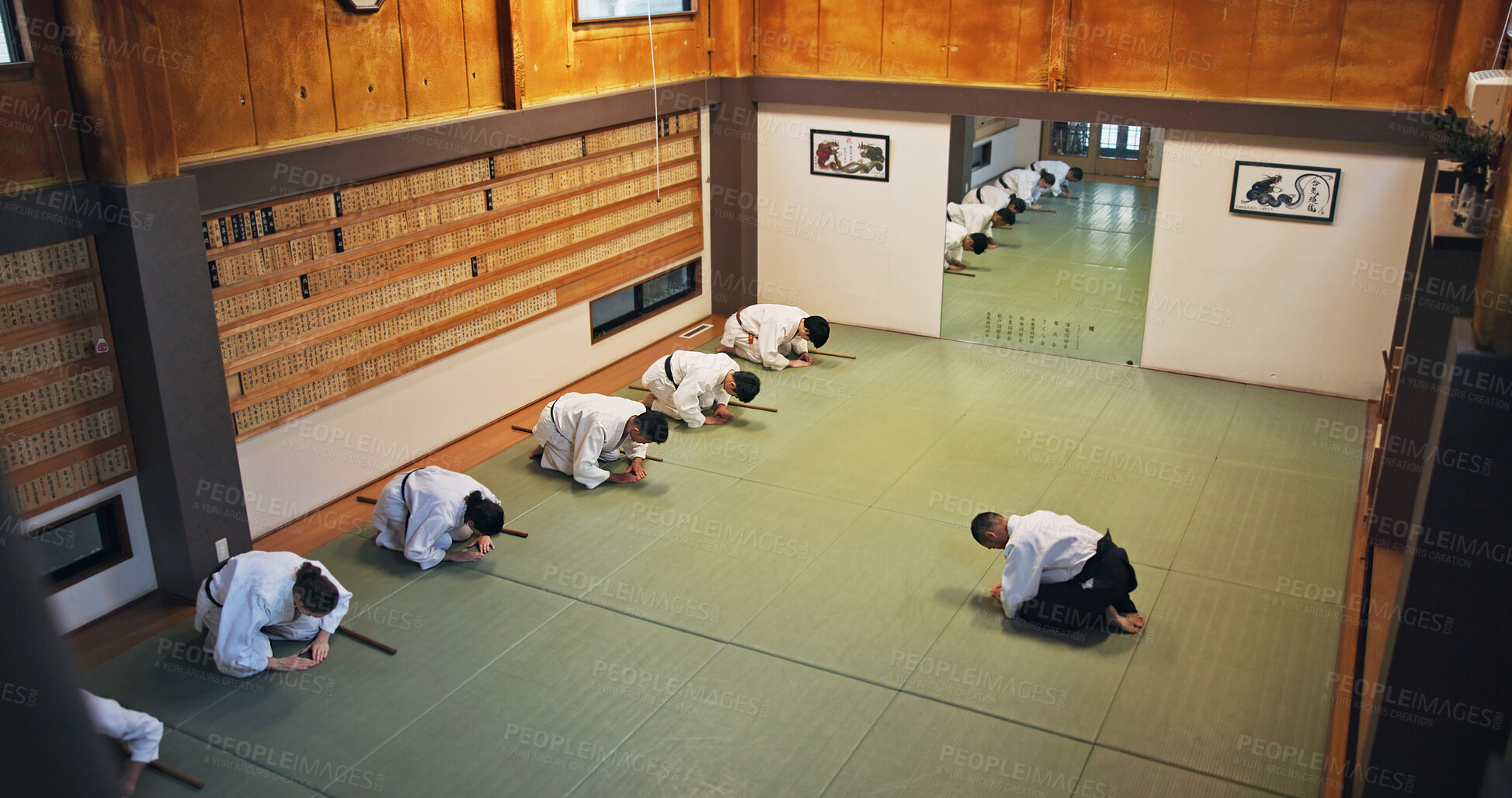 Buy stock photo Bow, greeting and people in martial arts studio for practice, training or self defense class. Culture, karate and group of students with respect or etiquette gesture to master in dojo for honor.