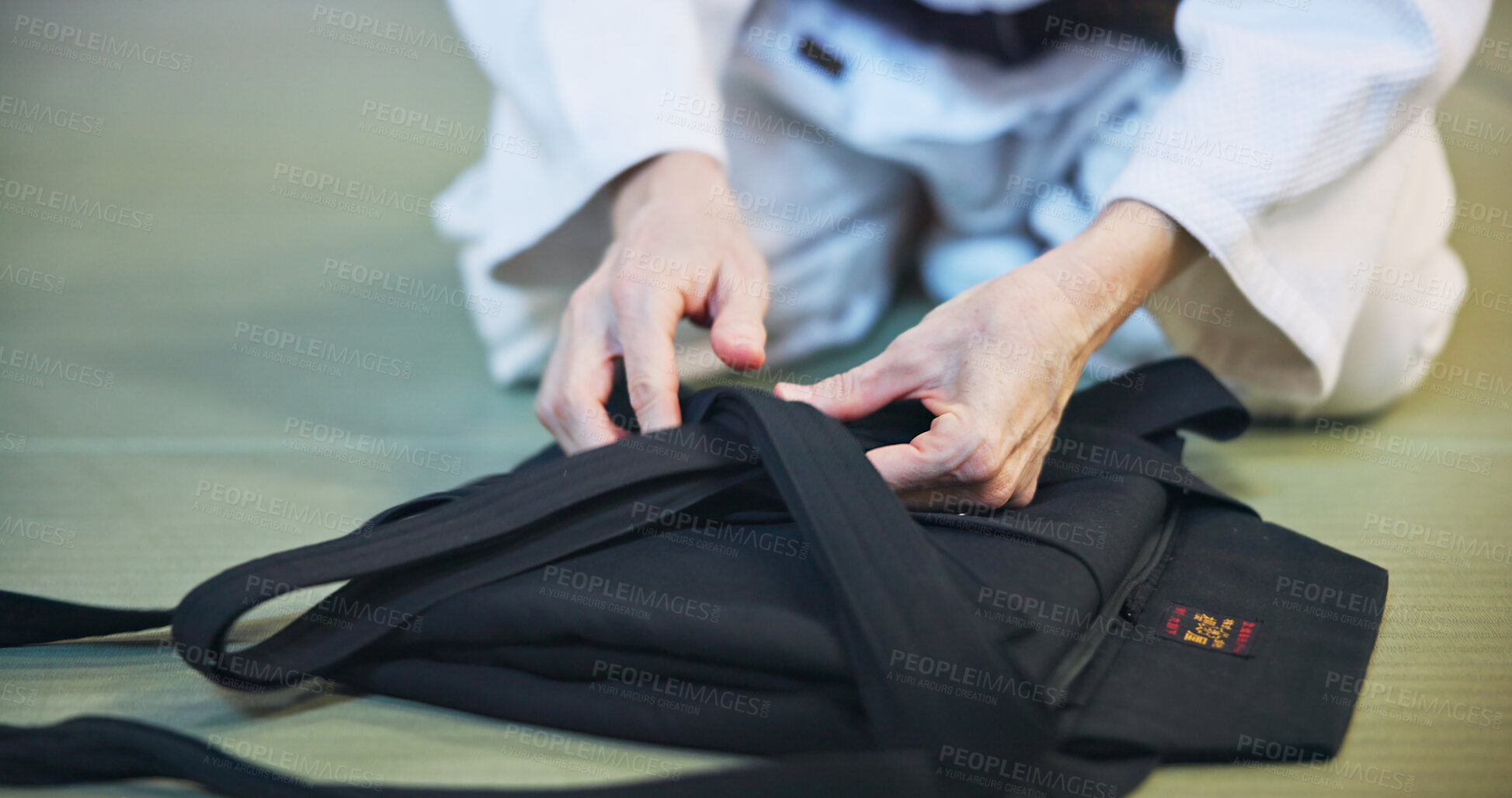 Buy stock photo Person, hands and clothing with uniform for martial arts, fashion and aikido gi on floor in dojo. Japan, culture or black belt fighter with material, fabric or traditional outfit for self defense