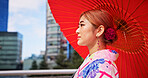 Asian woman, umbrella and travel with kimono in city for tradition, culture or heritage. Japan, female person or tourist with red sunshade or fashion for tourism, event or festival in an urban town