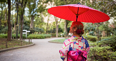 Buy stock photo Kimono, umbrella and walking with woman in park to explore green location for sightseeing or tourism. Back, fashion and travel with person outdoor in nature of Japan for culture, holiday or vacation