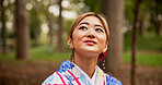 Asian woman, face and travel with kimono in nature for sightseeing, adventure or outdoor journey. Japan, female person or tourist with smile, fashion or wonder for tradition, culture or heritage