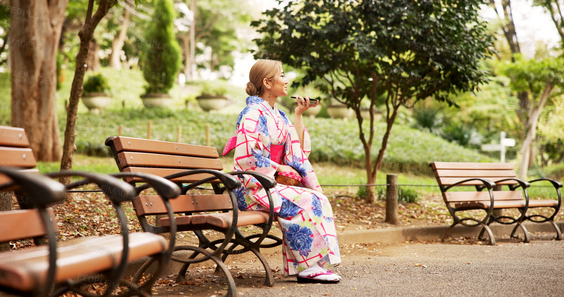 Buy stock photo Asian woman, park bench and communication with phone for voice message, conversation or vocal audio in nature. Japan, female person or tourist with mobile smartphone, speaker or kimono for chat app