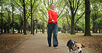 Park, woman and happy with walking dog for exercise, health and bonding in Japan. Outdoor, forest and mature person as pet owner with animal for friendship, love and care with smile for adoption