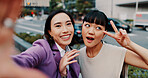 Business women, selfie and together in street with smile for peace sign, partner or excited for post on web. People, partnership and photography in city, happy or emoji with profile picture in Japan