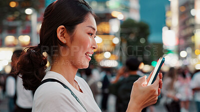 Buy stock photo Woman, phone and smile for travel in city, reading and check notification for chat, night or network in street. Person, smartphone and typing on metro sidewalk, happy or app for social media in Japan