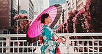 City, umbrella and Japanese woman in kimono walking on bridge with morning travel, sightseeing and style. Fashion, stroll and girl in traditional clothes, parasol and Asian culture on urban commute