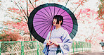 Sakura, park and girl with kimono, umbrella or sightseeing on outdoor adventure. Fashion, spring and happy Japanese woman walking with traditional clothes, parasol or culture in cherry blossom garden