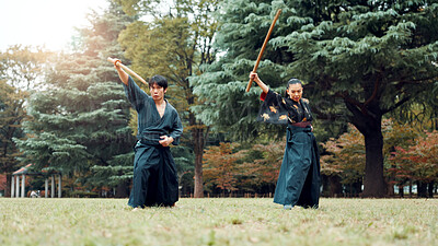 Buy stock photo Sword, martial arts and people in outdoor training together for aikido, fight coaching or samurai challenge in nature. Warrior, Japanese man and woman in park for traditional bokken battle with wood