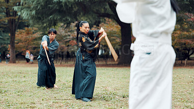Buy stock photo Sword, martial arts and people in outdoor class together for aikido training, fight coaching or samurai challenge in nature. Warrior, Japanese man and woman in park for traditional bokken battle kata