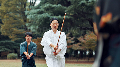 Buy stock photo Weapon, Japanese people and outdoor in training, exercise and sports for martial arts or aikido. Student, wooden sword and heritage with challenge, combat and practice as defense technique or bojutsu