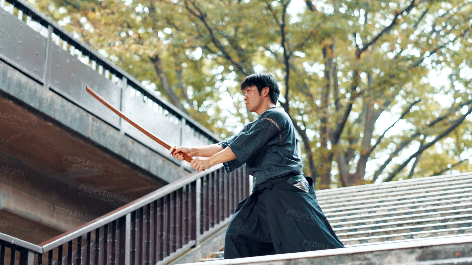 Buy stock photo City, bamboo sword and Asian man for martial arts, Kendo practice and exercise. Culture, heritage and person with shinai, bokuto and weapon on stairs for skill, fight or traditional training in Japan