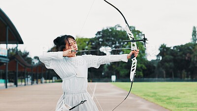 Buy stock photo Aim, athlete and woman with bow, field and serious for challenge, training and equipment for sport. Outdoor, skills and talent for archery, shooting and arrow for practice, archer and person in Japan